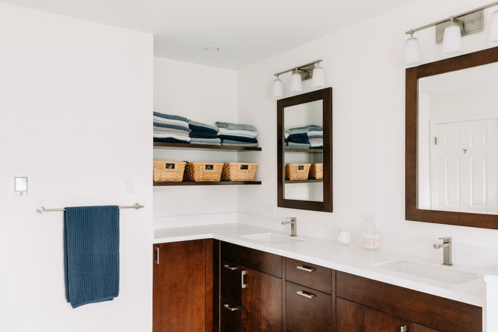 Double vanity with chrome bar pulls in Ardmore, PA bathroom remodel — Walnut Shaker double vanity, Corian countertops, glass shower