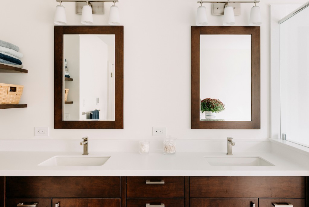 Square undermount sinks and white quartz countertop in Ardmore, PA bathroom remodel — Walnut Shaker double vanity, Corian countertops, glass shower
