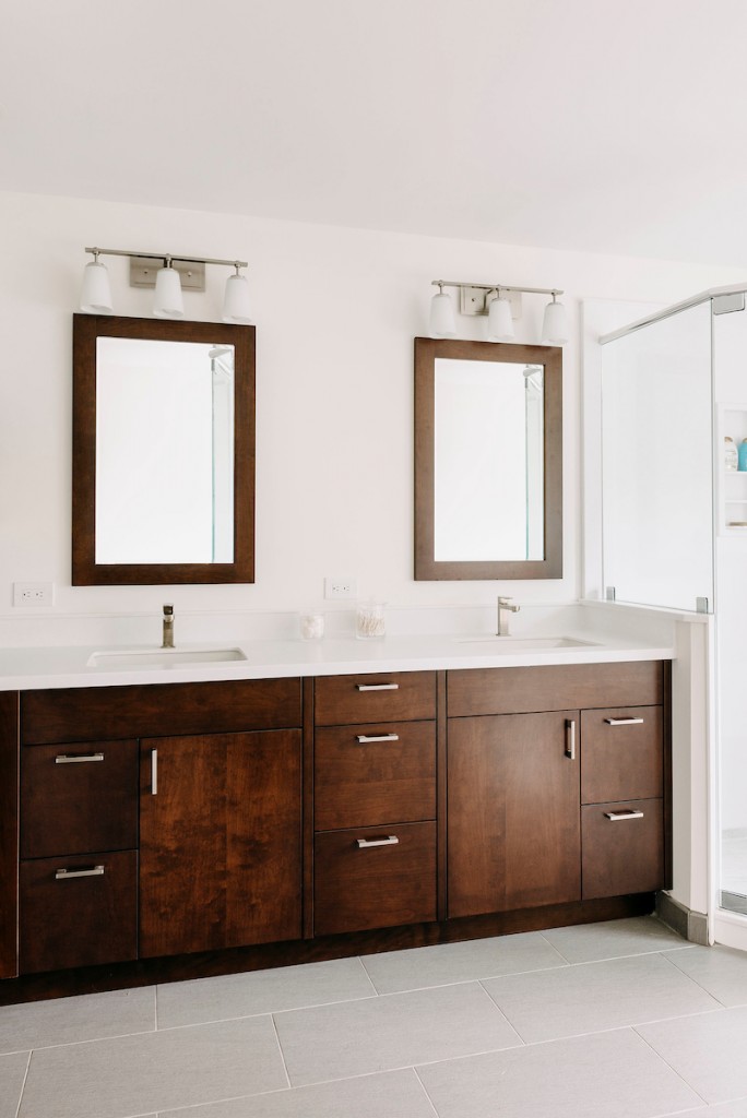 Frameless glass shower interior in Ardmore, PA bathroom remodel — Walnut Shaker double vanity, Corian countertops, glass shower
