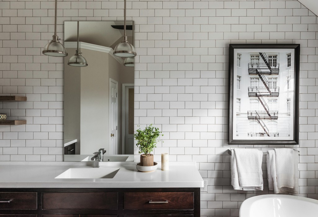 Polished nickel pendants and dark wood-framed mirror in Berwyn, PA bathroom remodel — Espresso inset Shaker double vanity, Corian
