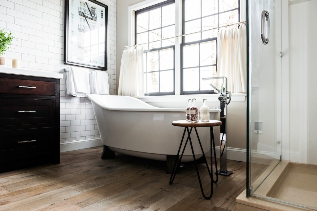 Slipper tub on rustic wood-look floor in Berwyn, PA bathroom remodel — Espresso inset Shaker double vanity, Corian