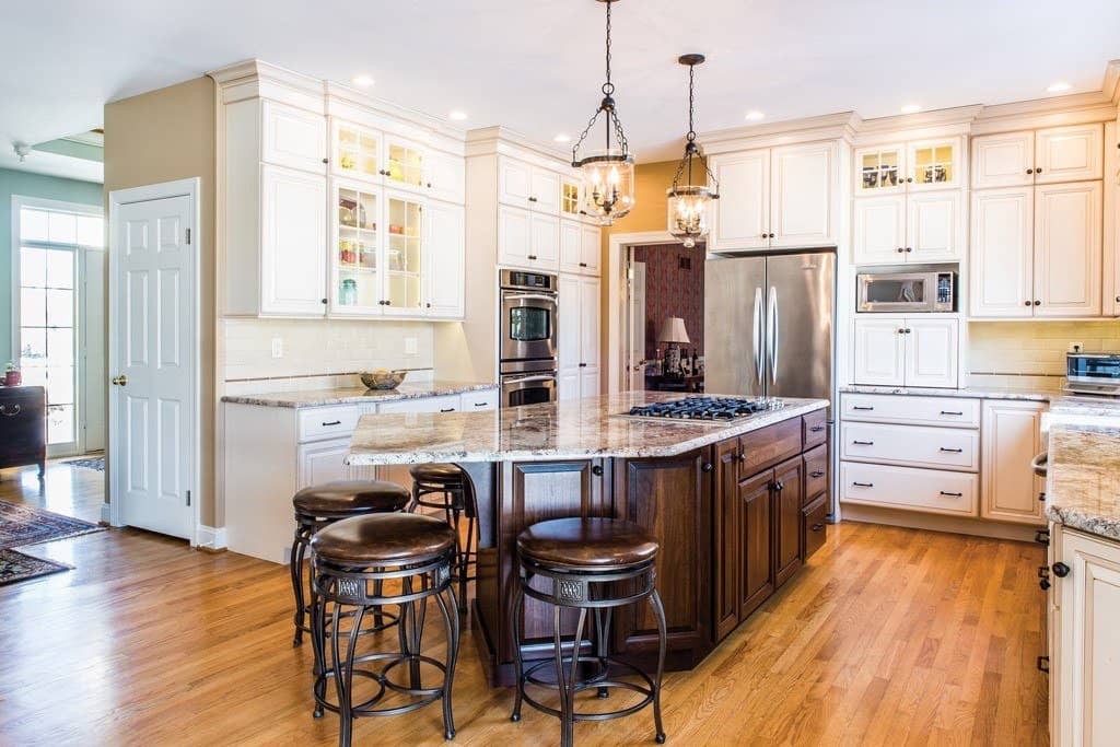 Cream raised-panel cabinetry kitchen with stained walnut island and granite in Berwyn, PA — kitchen remodel by Fedor Fabrication