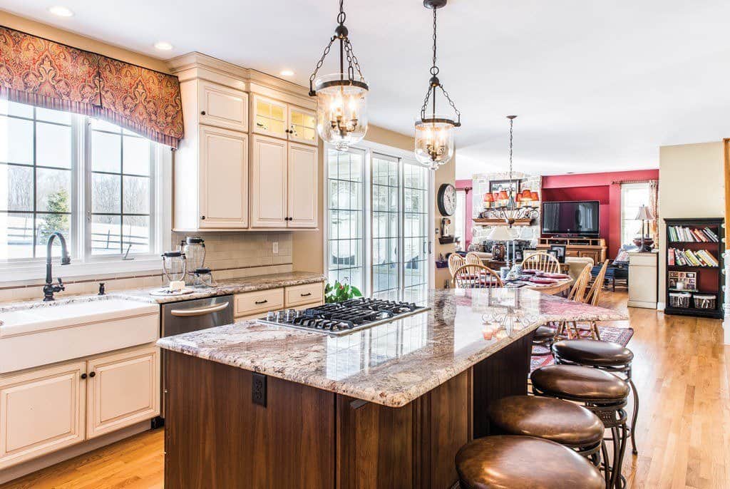 Open kitchen with light gray Shaker cabinetry in Berwyn, PA kitchen remodel — Cream raised-panel cabinetry