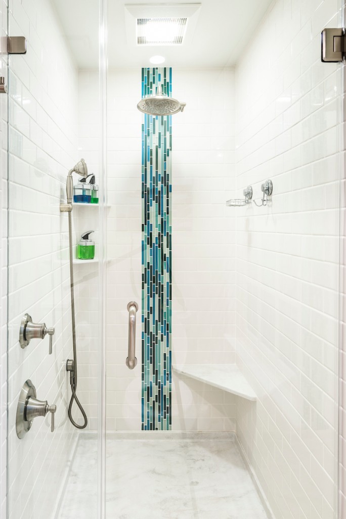 Vertical blue glass mosaic accent in white subway shower in Downingtown, PA bathroom remodel — Cream raised-panel vanity