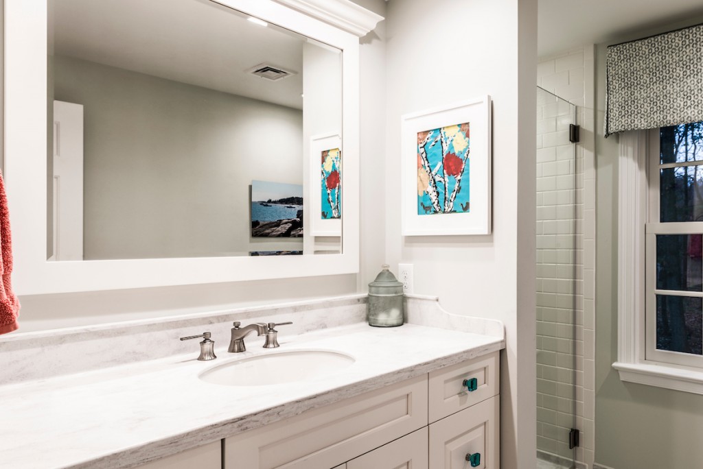 Mirror reflection of vanity area in Downingtown, PA bathroom remodel — Cream raised-panel vanity
