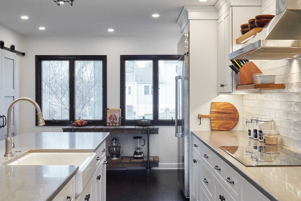 Exton kitchen fireclay farmhouse sink close-up on the island with quartz counter and brushed nickel high-arc faucet