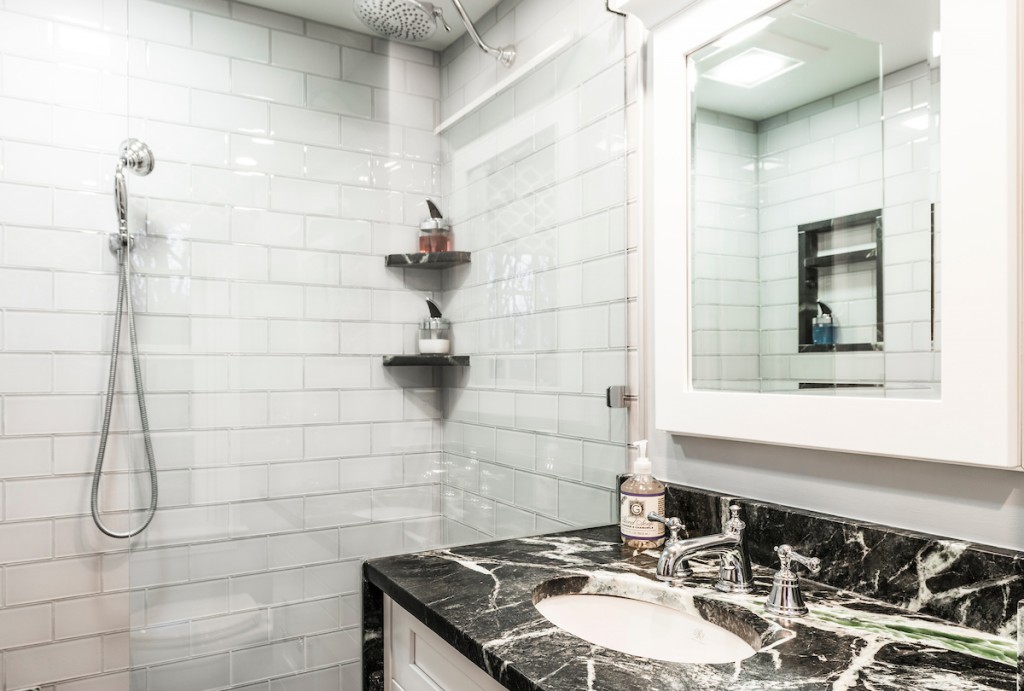 White Shaker cabinetry vanity with dramatic black-and-emerald marble counter in Kennett Square, PA — bathroom remodel by Fedor Fabrication