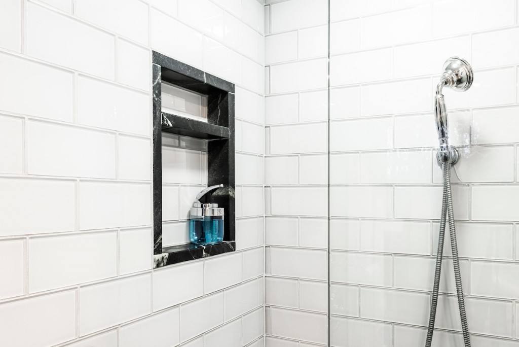 Black marble framed shower niche in Kennett Square, PA bathroom remodel — White Shaker vanity
