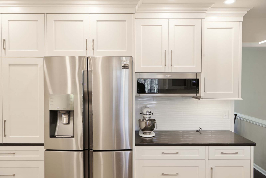 Stained cherry island with two-tone Shaker cabinetry in Kennett Square, PA kitchen remodel — White Shaker cabinetry