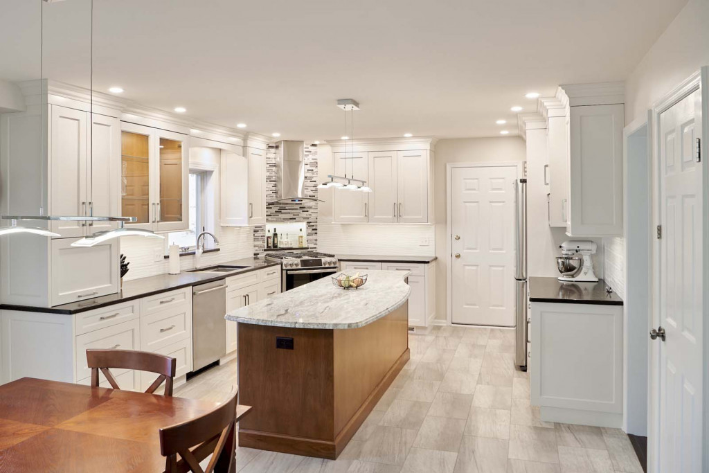 White Shaker cabinetry kitchen with curved stained-maple island and arched glass range hood in Kennett Square, PA — kitchen remodel by Fedor Fabrication