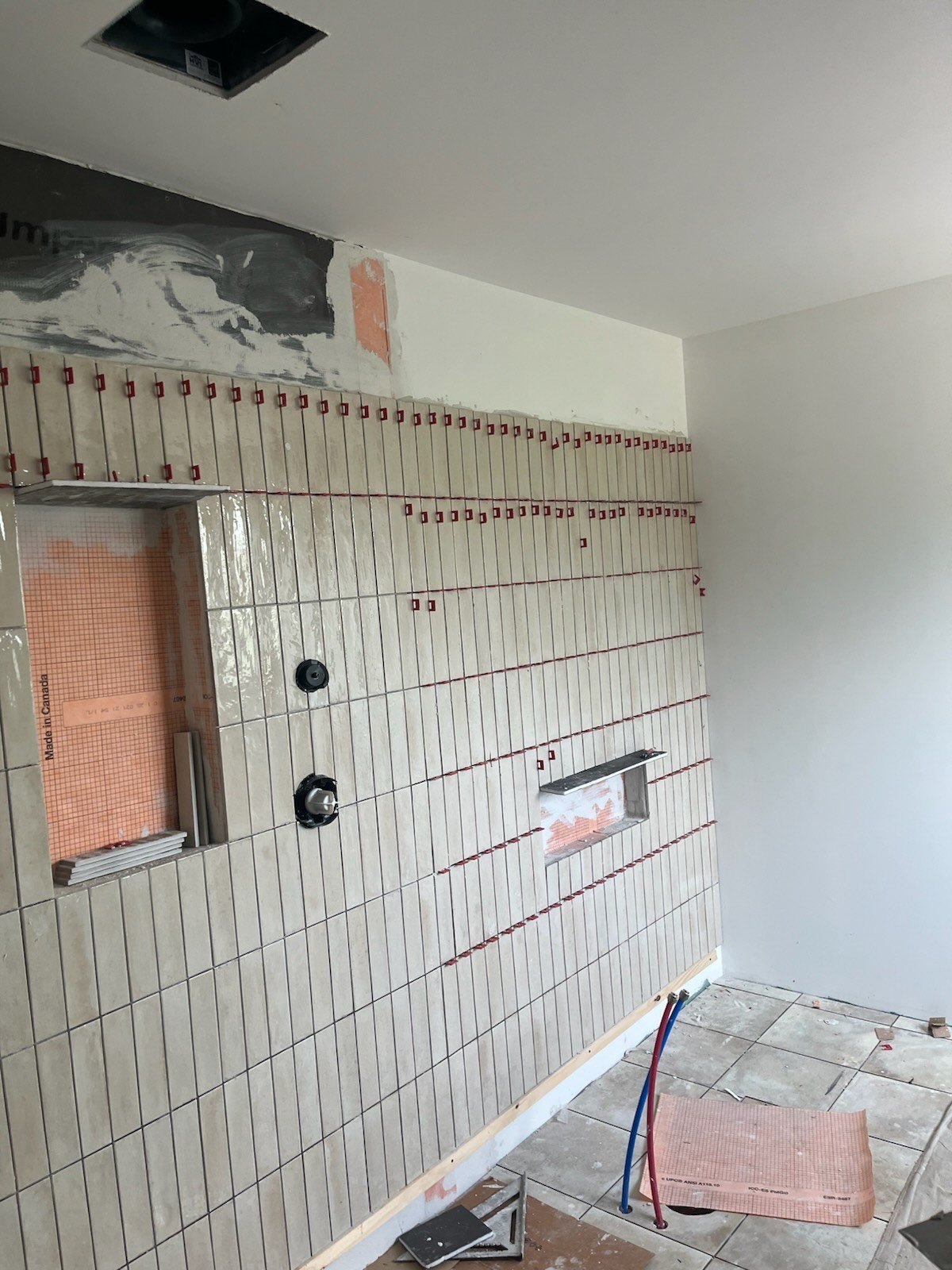 Look Lino wall tile being set with leveling clips over waterproofing