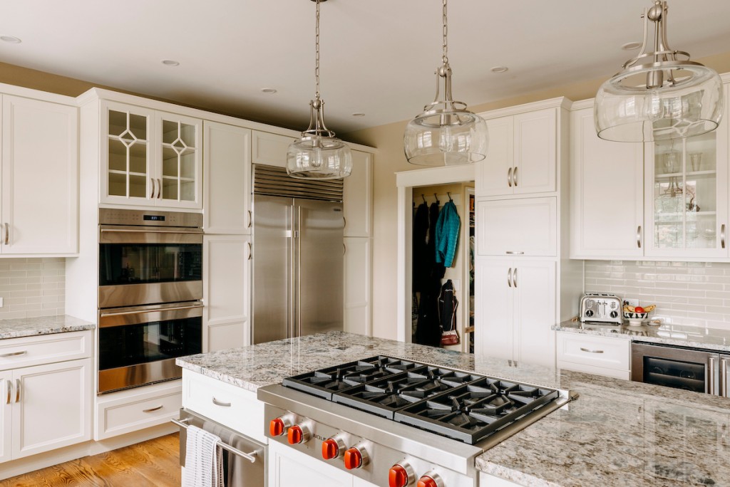 White recessed-panel cabinetry kitchen with French wine-crate clad island and globe pendants in Media, PA — kitchen remodel by Fedor Fabrication
