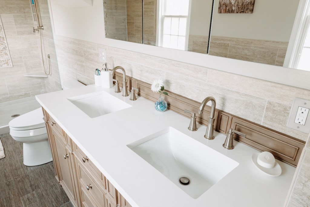 White quartz countertop with double rectangular undermount sinks in Newtown Square, PA bathroom remodel — Cerused oak raised-panel double vanity