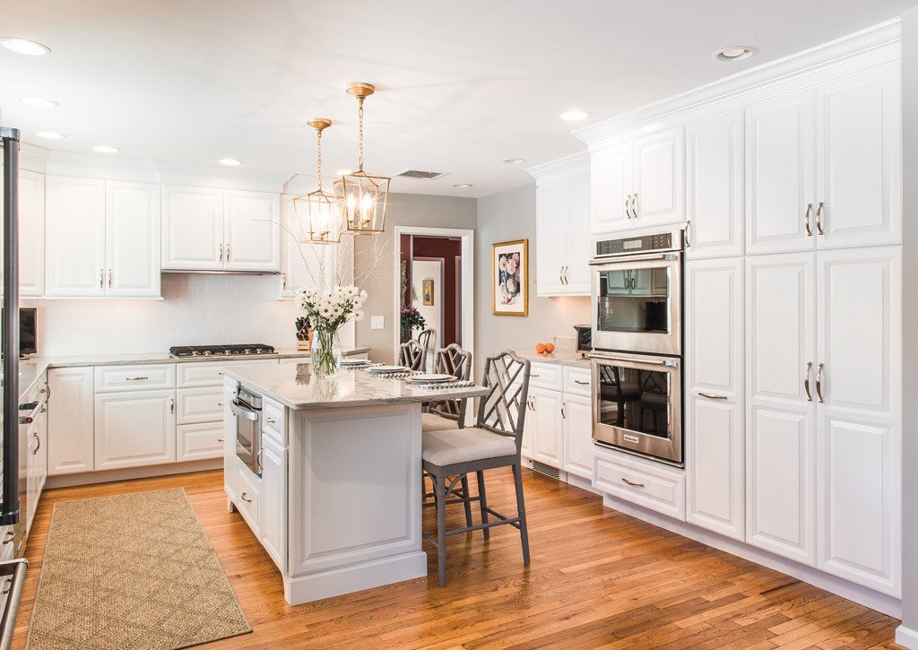 Cream raised-panel cabinetry kitchen with brass lantern pendants and arched window in Newtown Square, PA — kitchen remodel by Fedor Fabrication