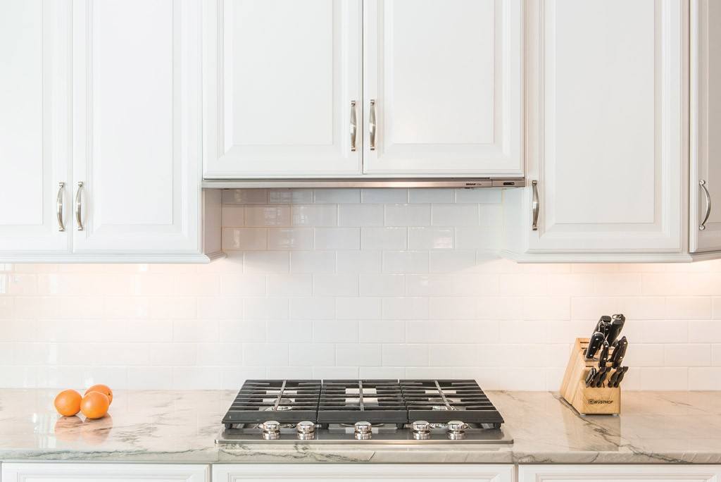 Subway Cooktop in Newtown Square, PA kitchen remodel — Cream raised-panel cabinetry