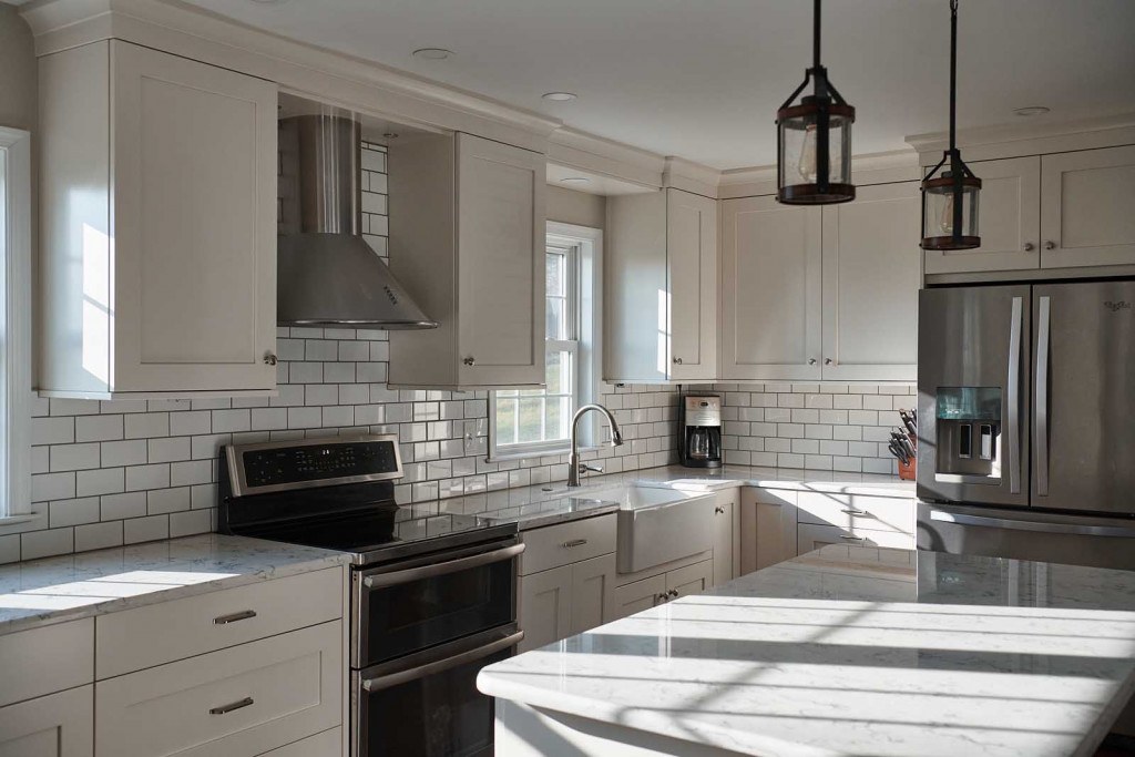 Villanova kitchen island with quartz top, white Shaker base, and beadboard backer panel detail