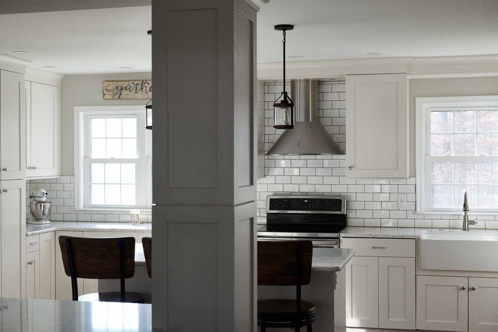 Villanova subway tile kitchen view from the seating side of the island with industrial pendants overhead
