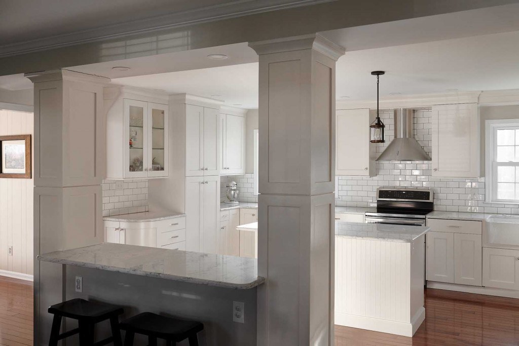 Villanova kitchen detail showing fireclay farmhouse sink, quartz counter, and dark-grout subway tile