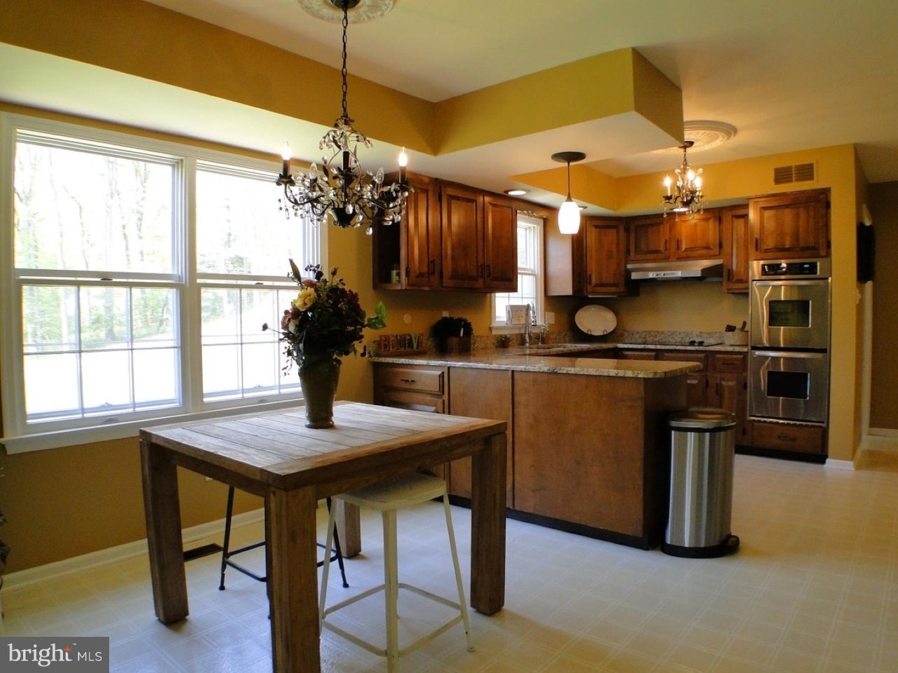 Villanova kitchen before — original golden oak cabinets and yellow-painted walls with the peninsula visible
