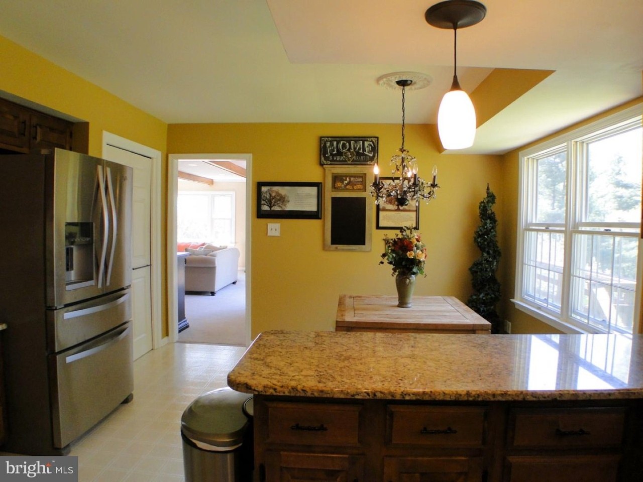 Villanova kitchen before — view of the original layout showing the peninsula seating, double wall oven, and tray ceiling