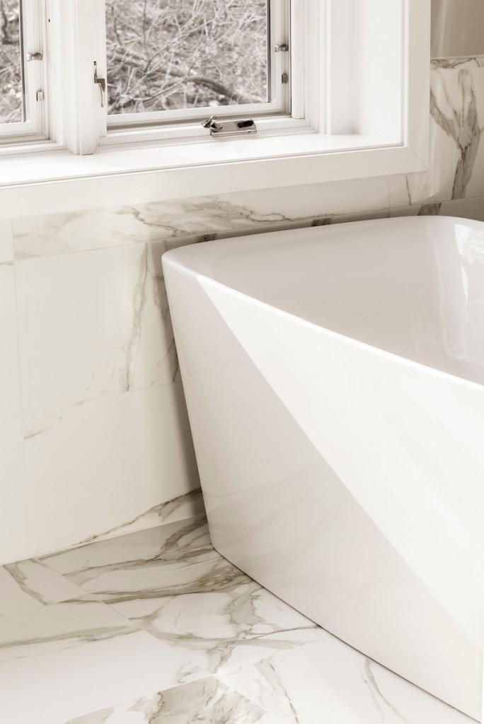 Soaker tub corner at casement window in Wayne, PA bathroom remodel — Quiet luxury master bath in Calacatta-look large-slab porcelain