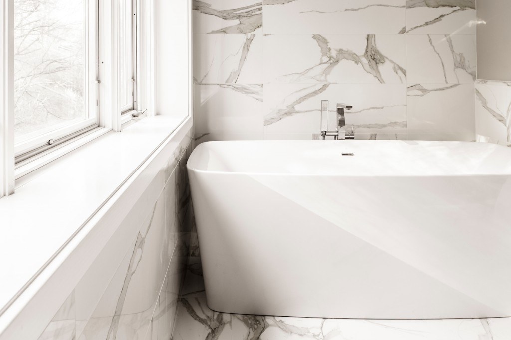 Large-format porcelain master bathroom with marble soaking tub in Wayne, PA — bathroom remodel by Fedor Fabrication