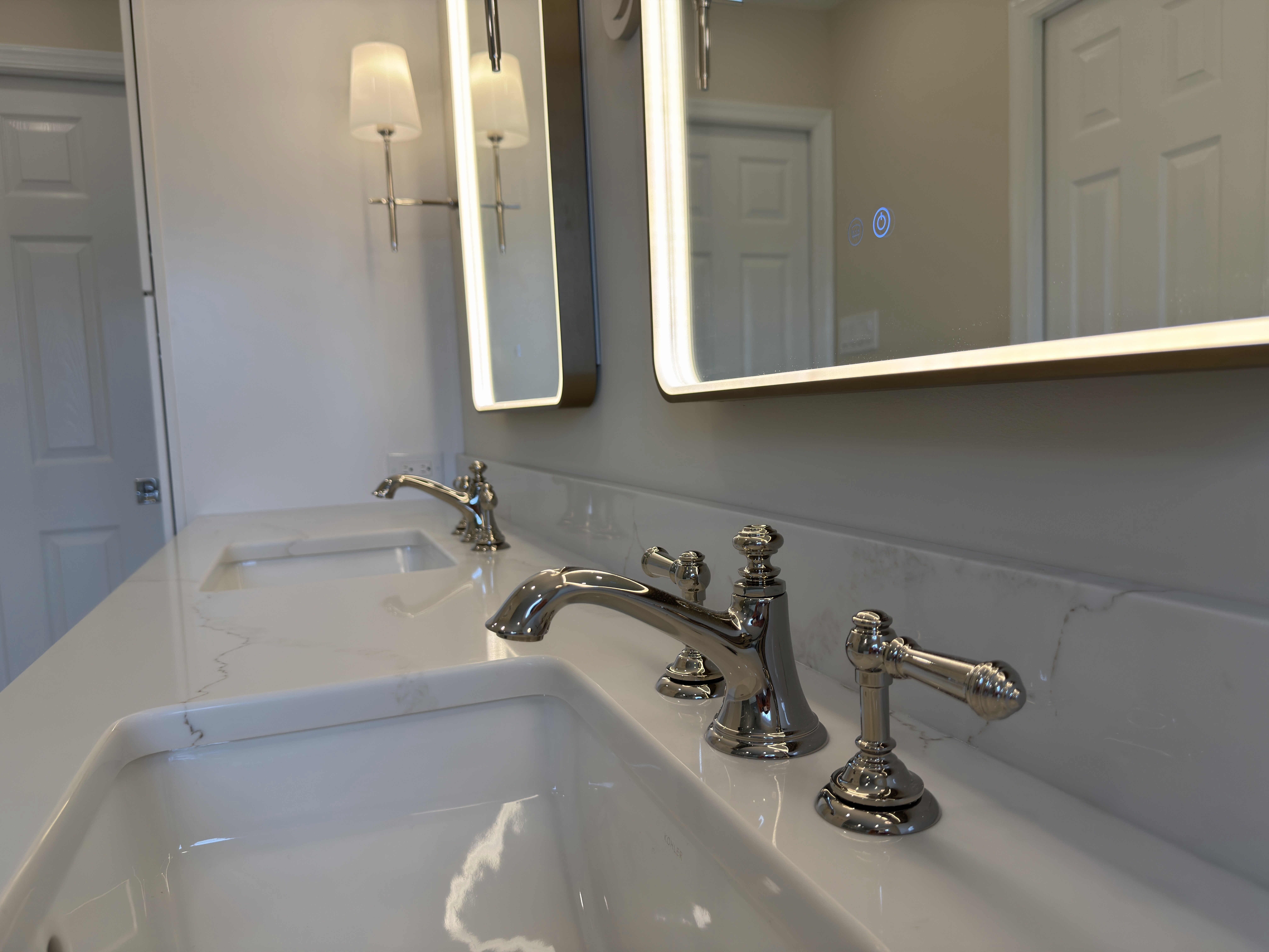 Polished nickel widespread faucet on Emerstone Borghini Gold quartz countertop with gold and grey veining