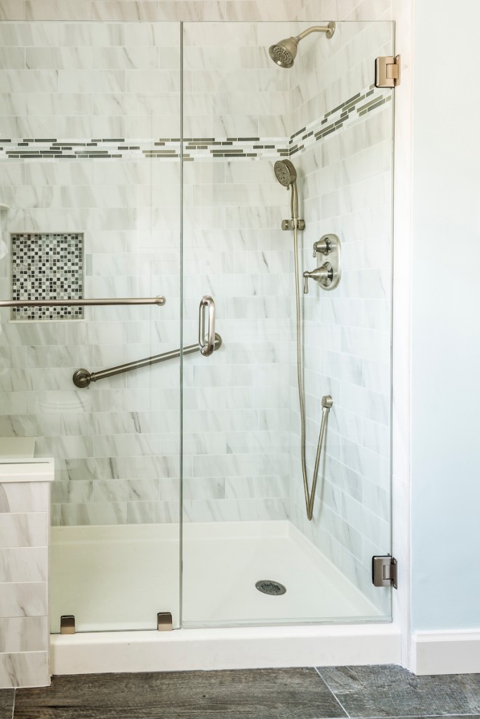 Brushed nickel rain head and handheld in marble subway shower in West Chester, PA bathroom remodel — Coastal seafoam primary
