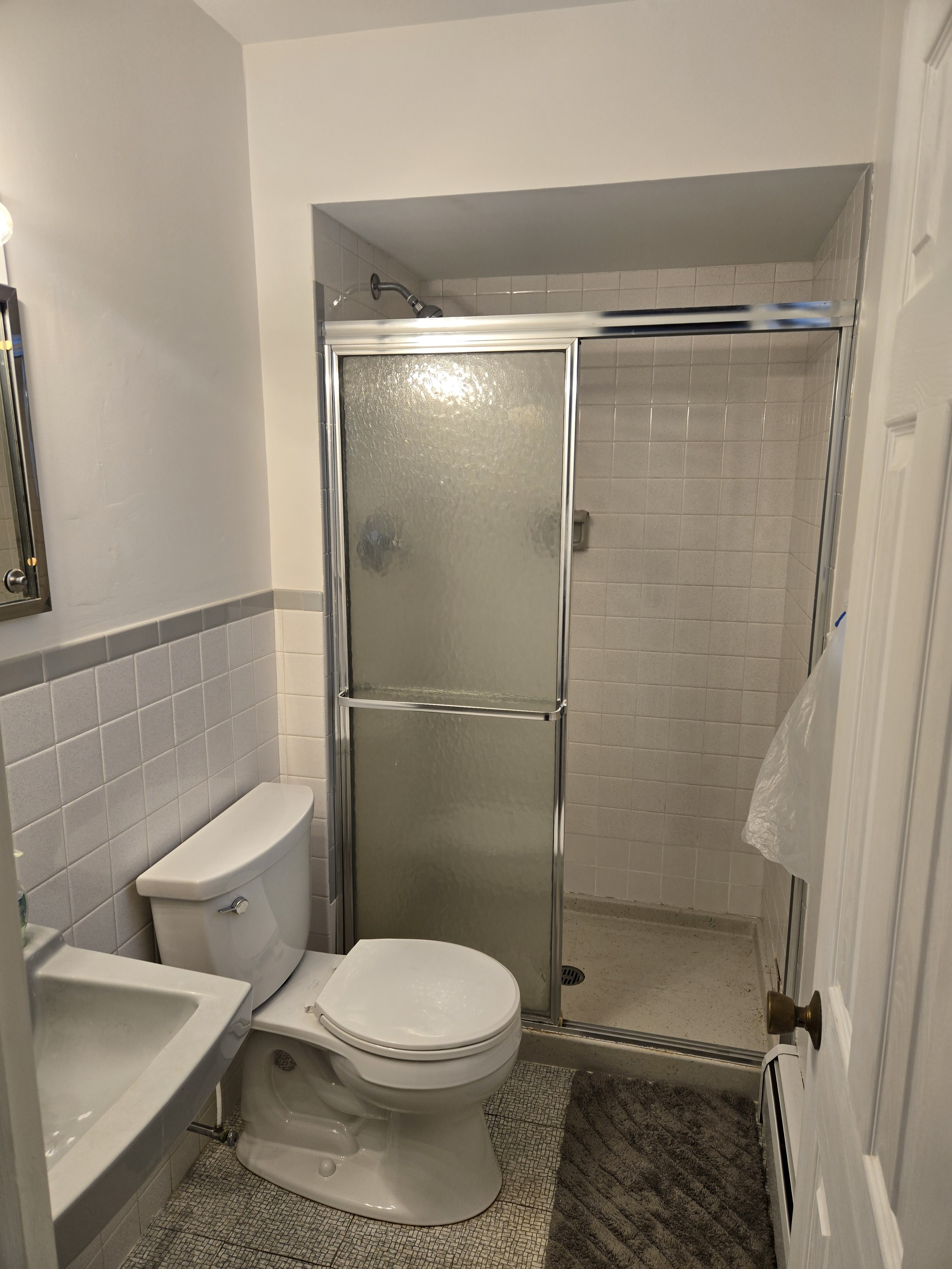 Original tub/shower combo with chrome-frame sliding doors — West Chester primary bathroom before remodel