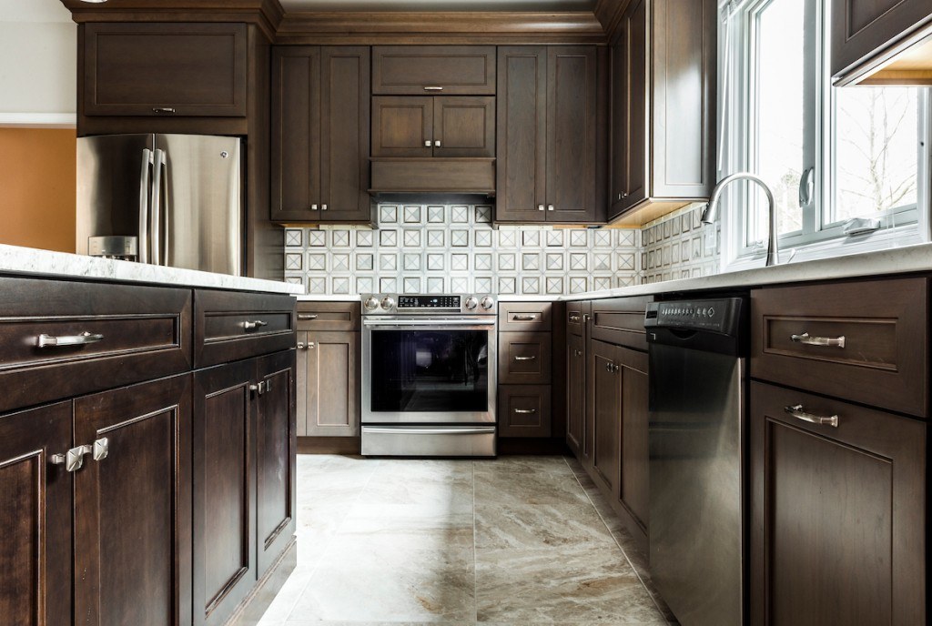 West Chester walnut kitchen view across the accent-quartz island toward the dining room with a terracotta accent wall