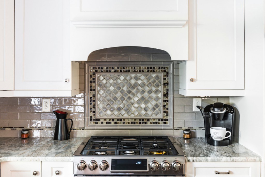West Chester eclectic kitchen close-up of the framed arabesque marble mosaic centerpiece over the stainless range