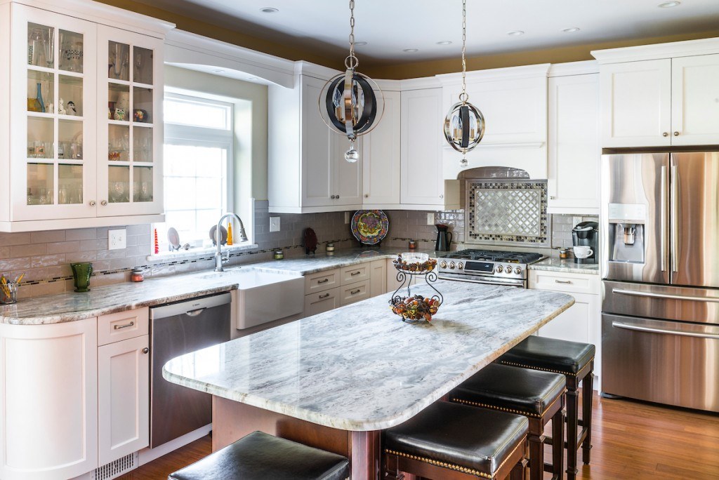 West Chester kitchen with two silver and chrome globe pendants over the dark-stained island and quartzite top