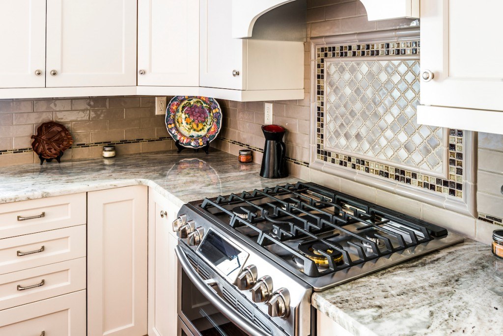 West Chester eclectic kitchen close-up of the stainless freestanding range with mosaic centerpiece directly above