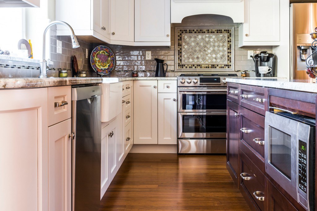 West Chester eclectic kitchen view across the island toward the range wall under globe pendants