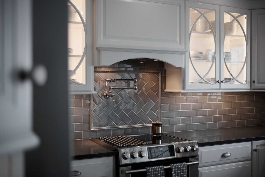 West Chester kitchen detail showing in-cabinet lighting glowing inside the half-circle mullion glass doors