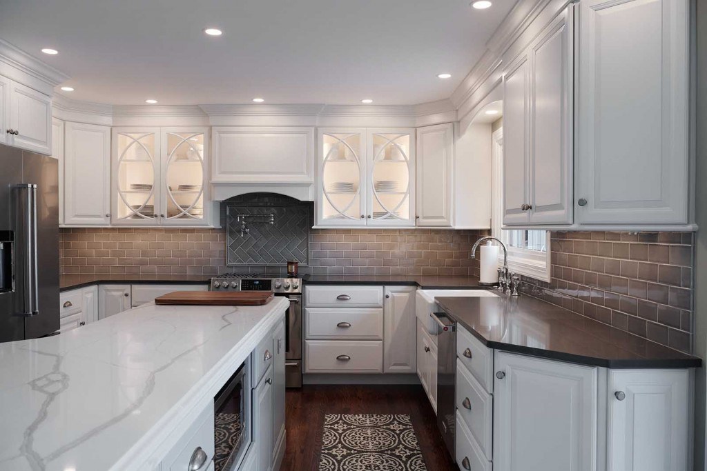 West Chester kitchen U-shape view showing the pale-blue island with Cambria quartz top, half-circle mullion uppers, and white perimeter cabinets