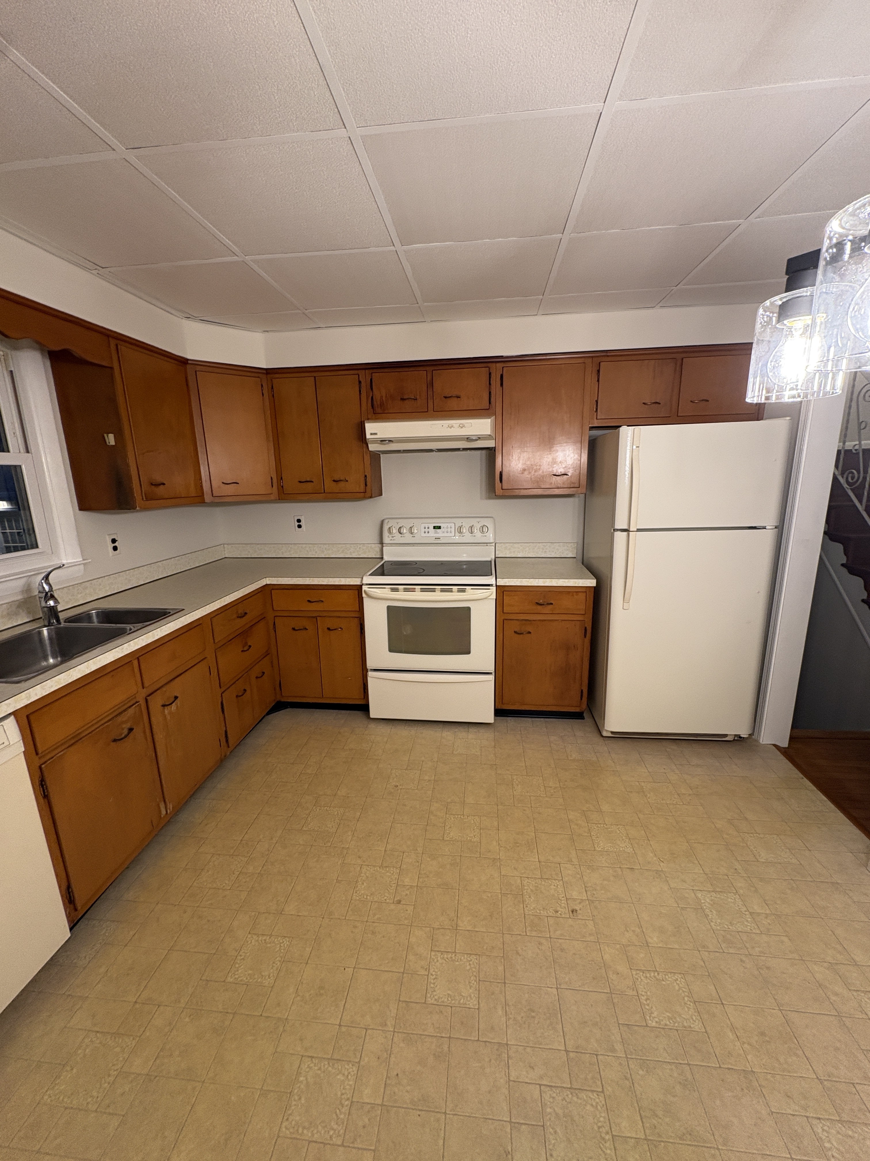 Original galley range wall — pine cabinets, white range, over-range microwave — West Chester kitchen before remodel