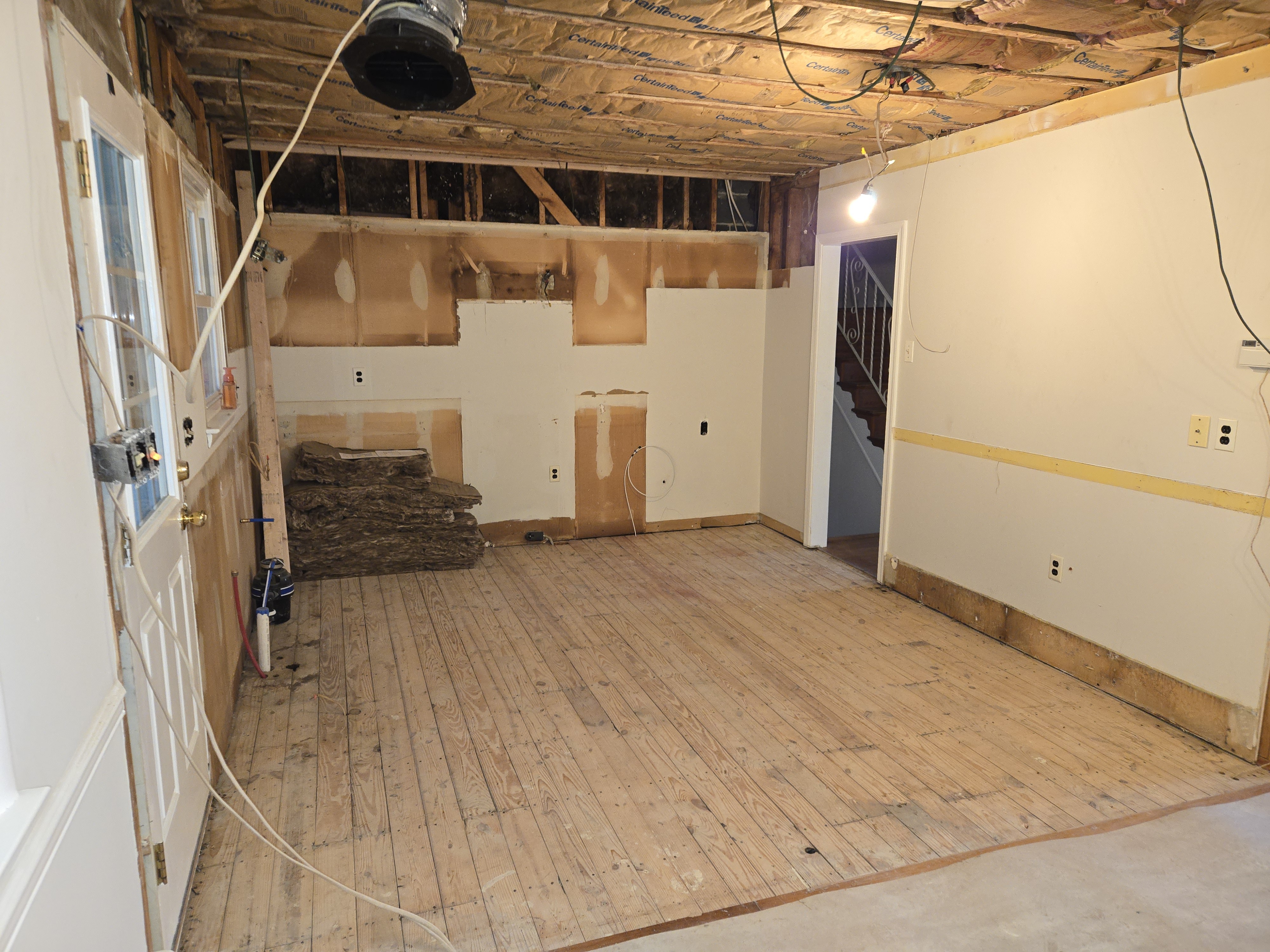 Walls stripped to studs, subfloor exposed, soffits removed — West Chester kitchen mid-construction
