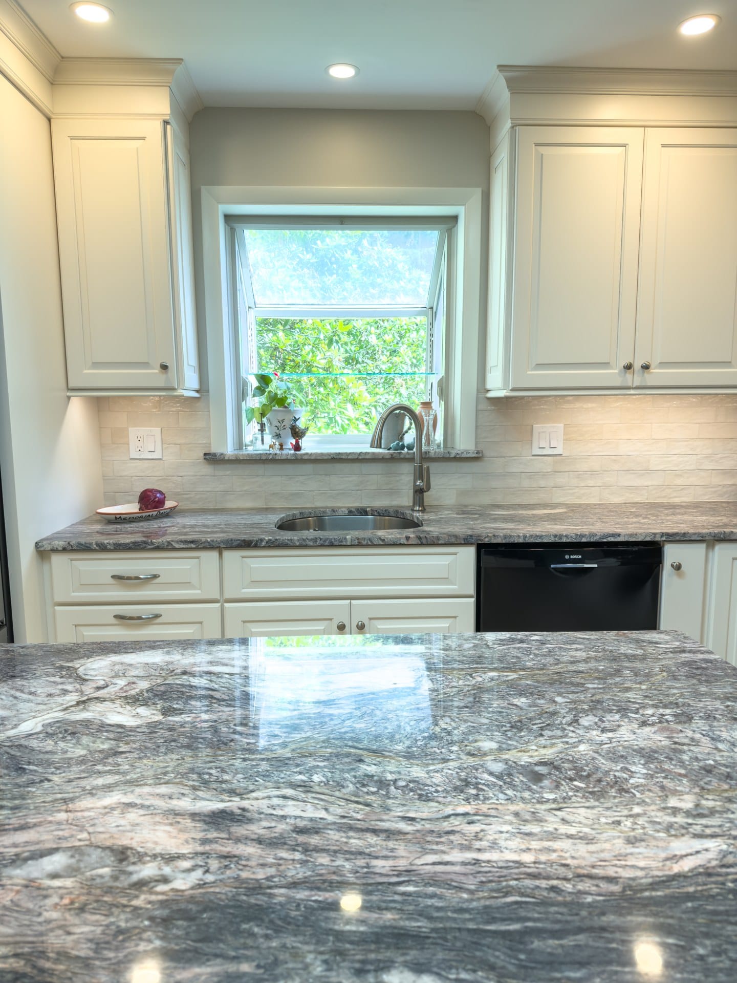 Granite counters and sink beneath a garden window in a Chester Springs kitchen remodel