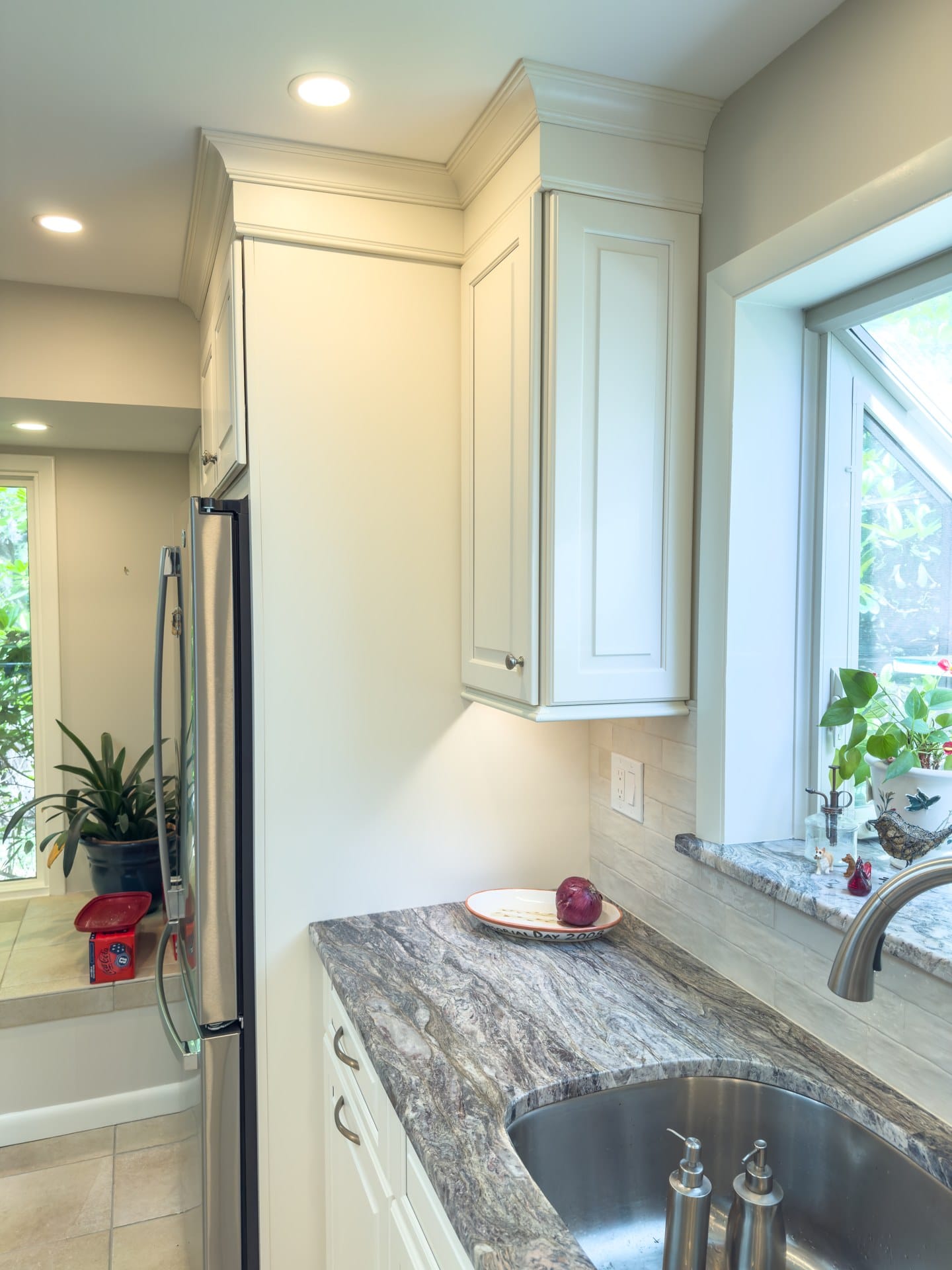 Corner of a remodeled Chester Springs kitchen with garden window, granite, and stainless refrigerator