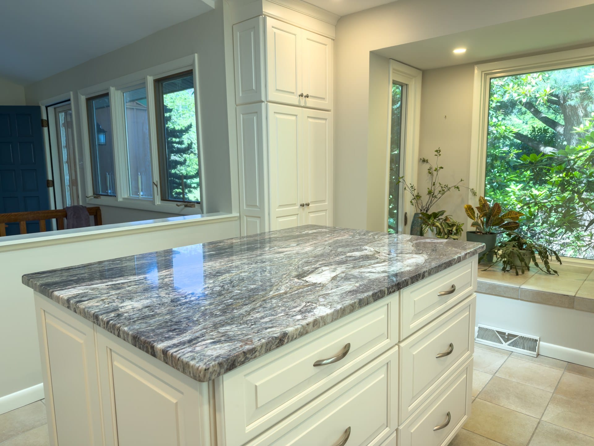 Granite island and custom cream cabinetry in a remodeled Chester Springs kitchen with corner window