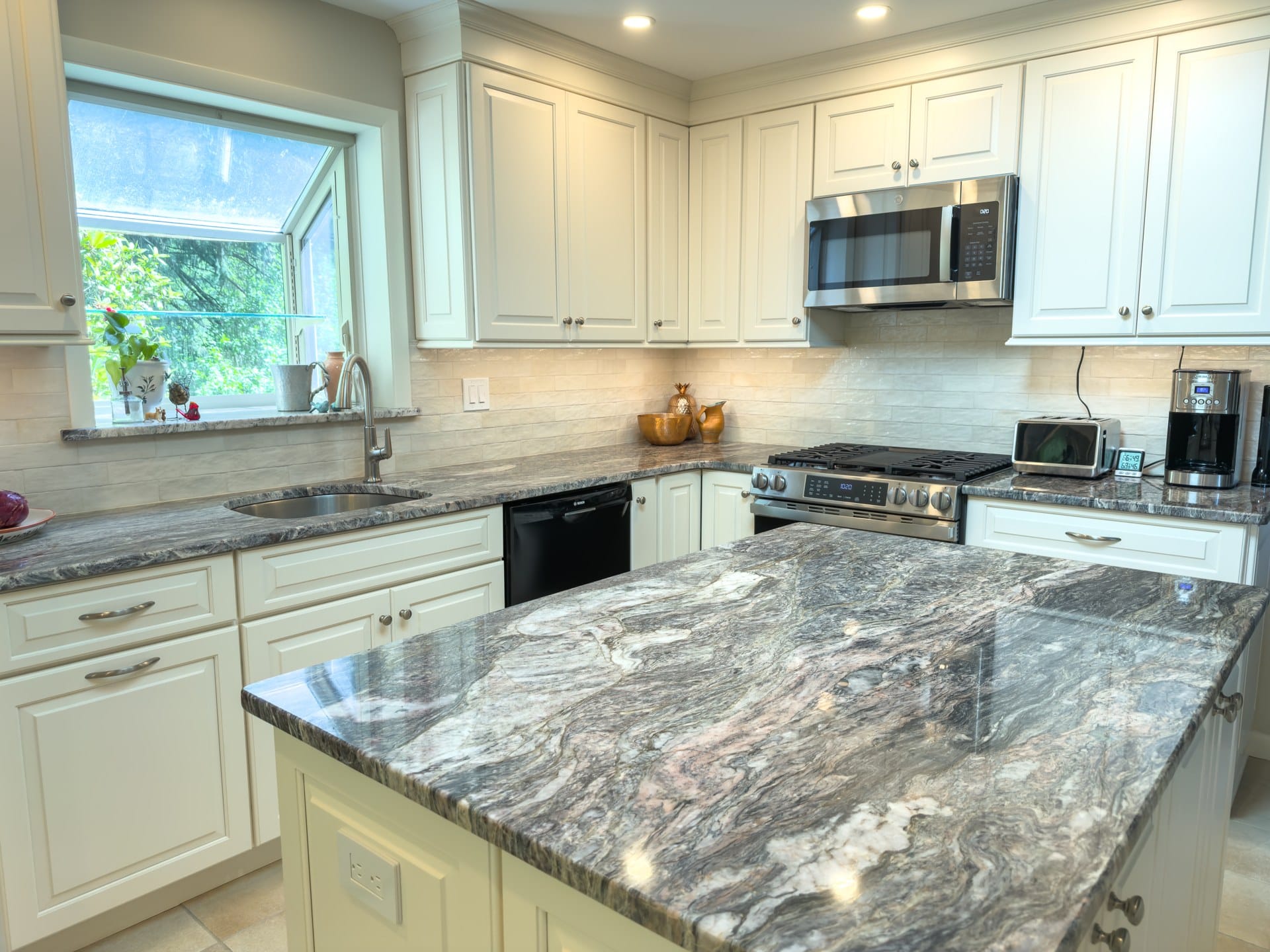 Chester Springs kitchen run with gas range, stainless microwave, granite counters, and tile backsplash