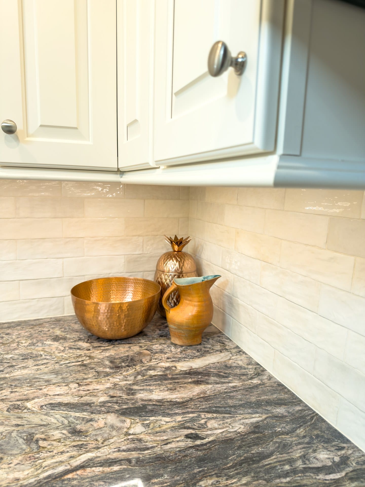 Detail of granite countertop and tile backsplash with cabinet hardware in a Chester Springs kitchen