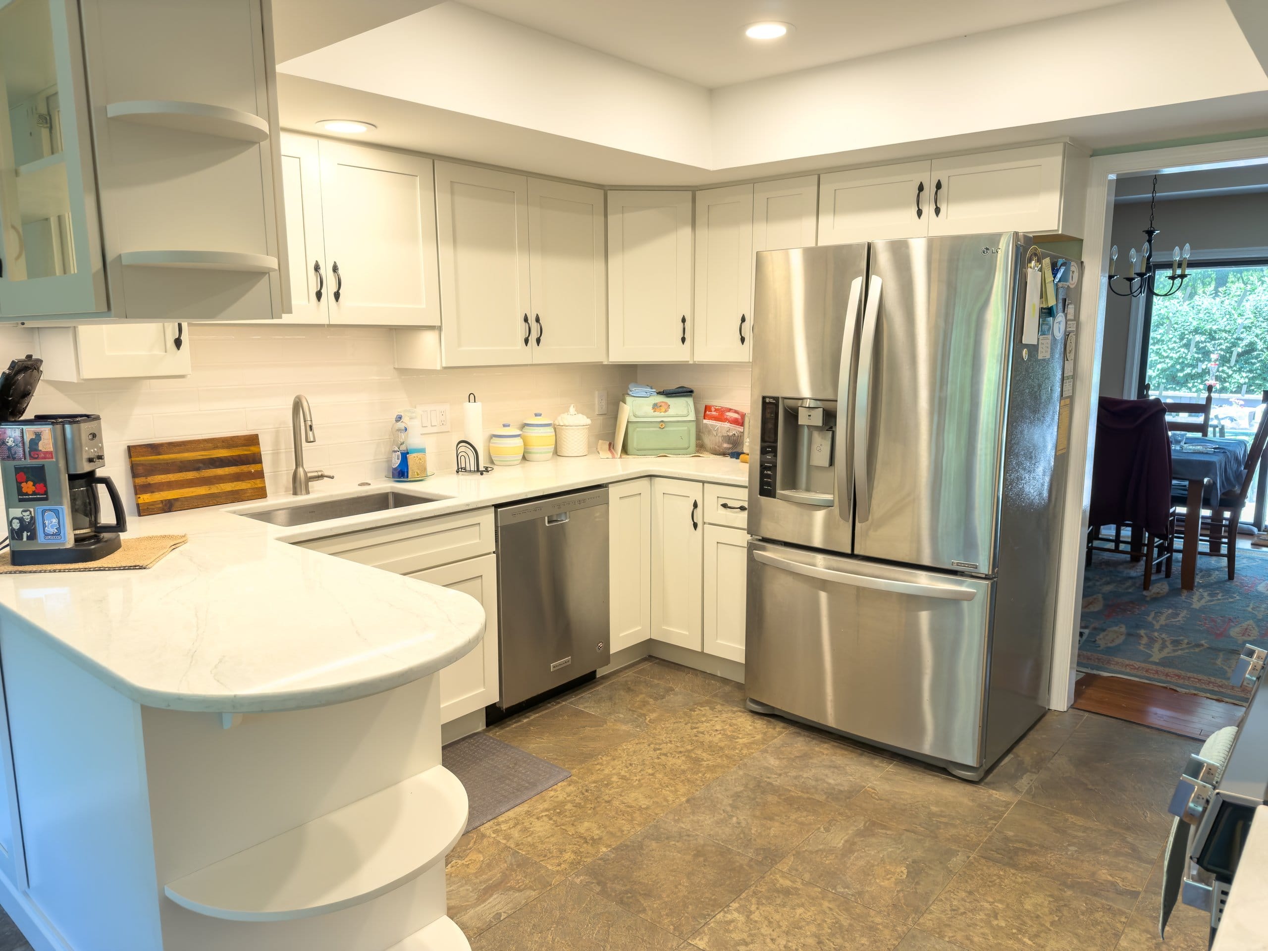 Wide view of the refreshed West Chester kitchen with stainless refrigerator and breakfast area beyond