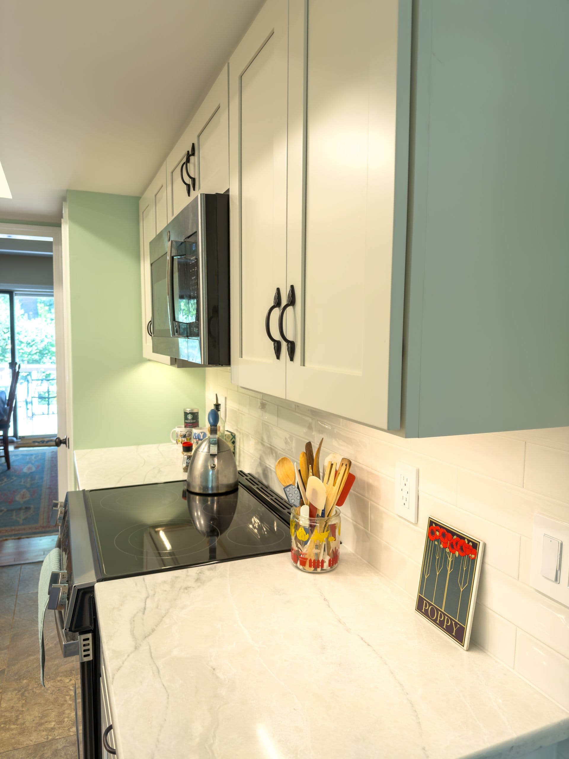 Corner of the range area showing the green accent wall and white upper cabinets