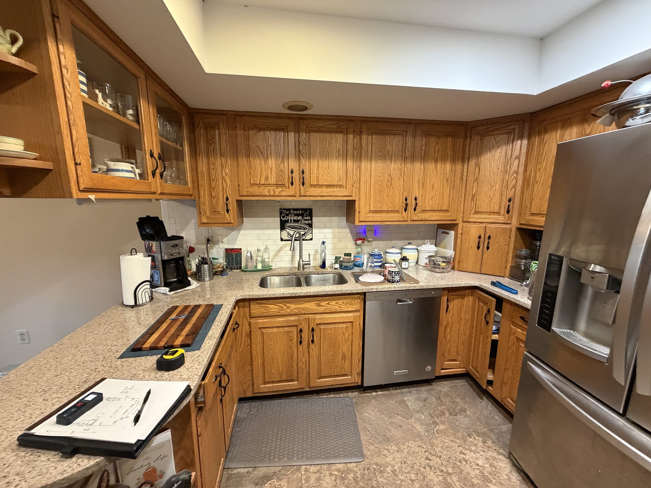 Before the refresh: oak sink run with laminate counters and a brown backsplash