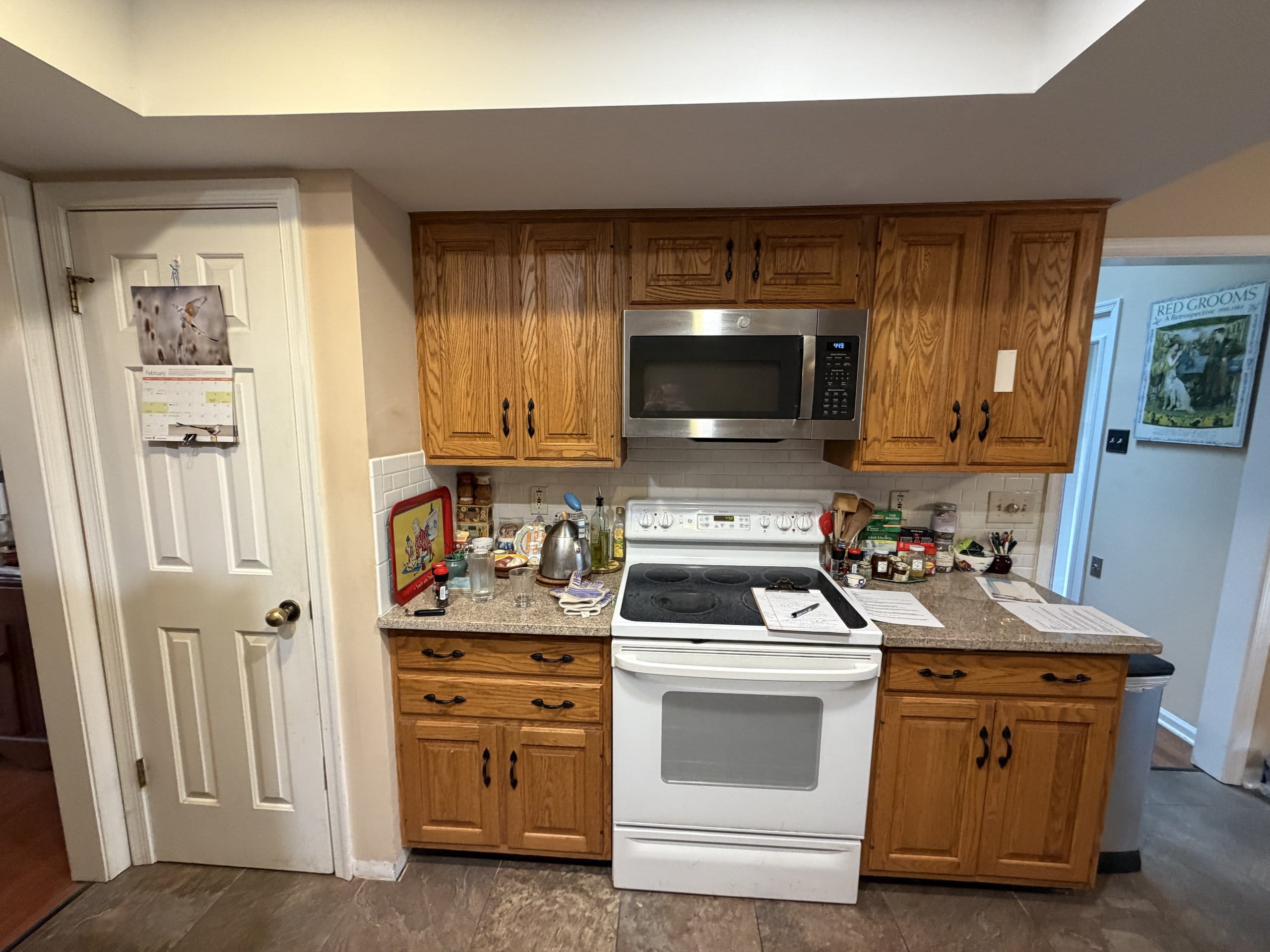 Before the refresh: oak cabinets surrounding a white electric range