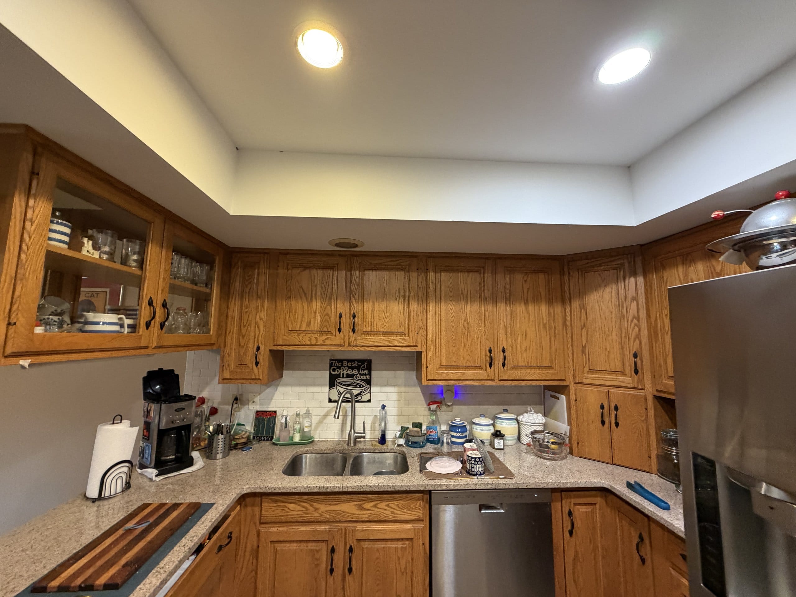 Before the refresh: dated oak kitchen with recessed soffit lighting