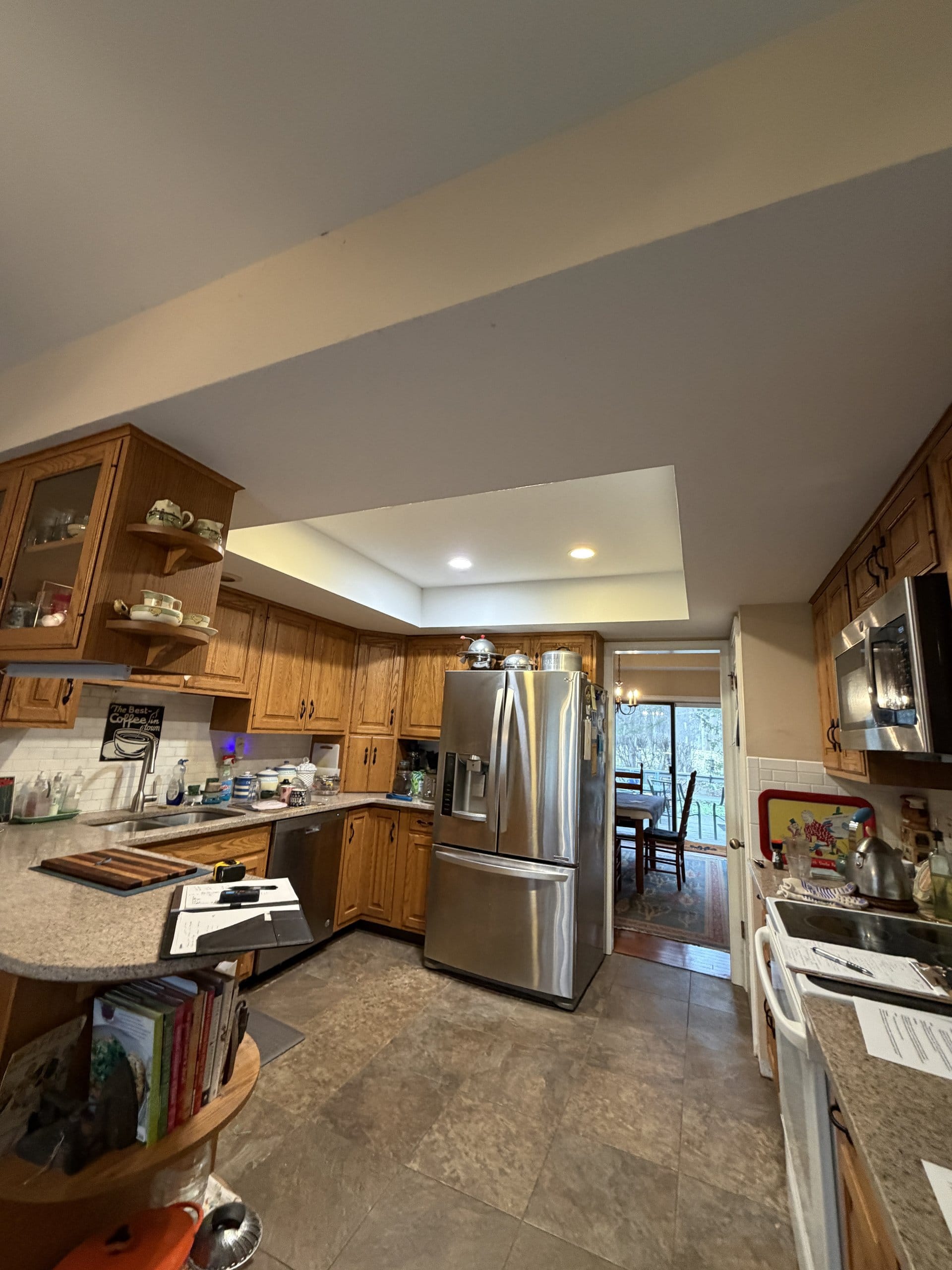 Before the refresh: oak peninsula and refrigerator looking toward the dining area